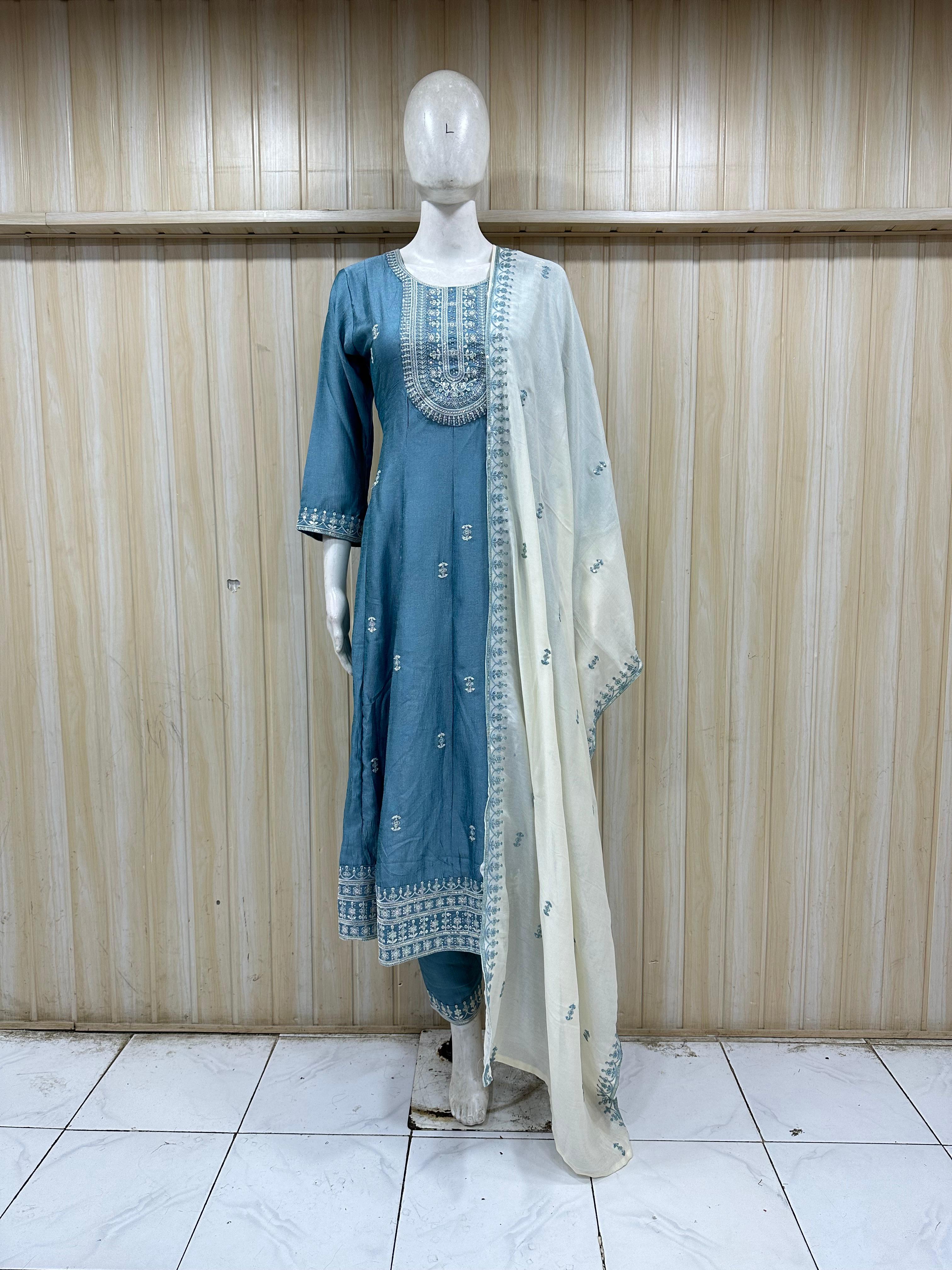 blue traditional outfit with intricate detailing on a mannequin against a striped