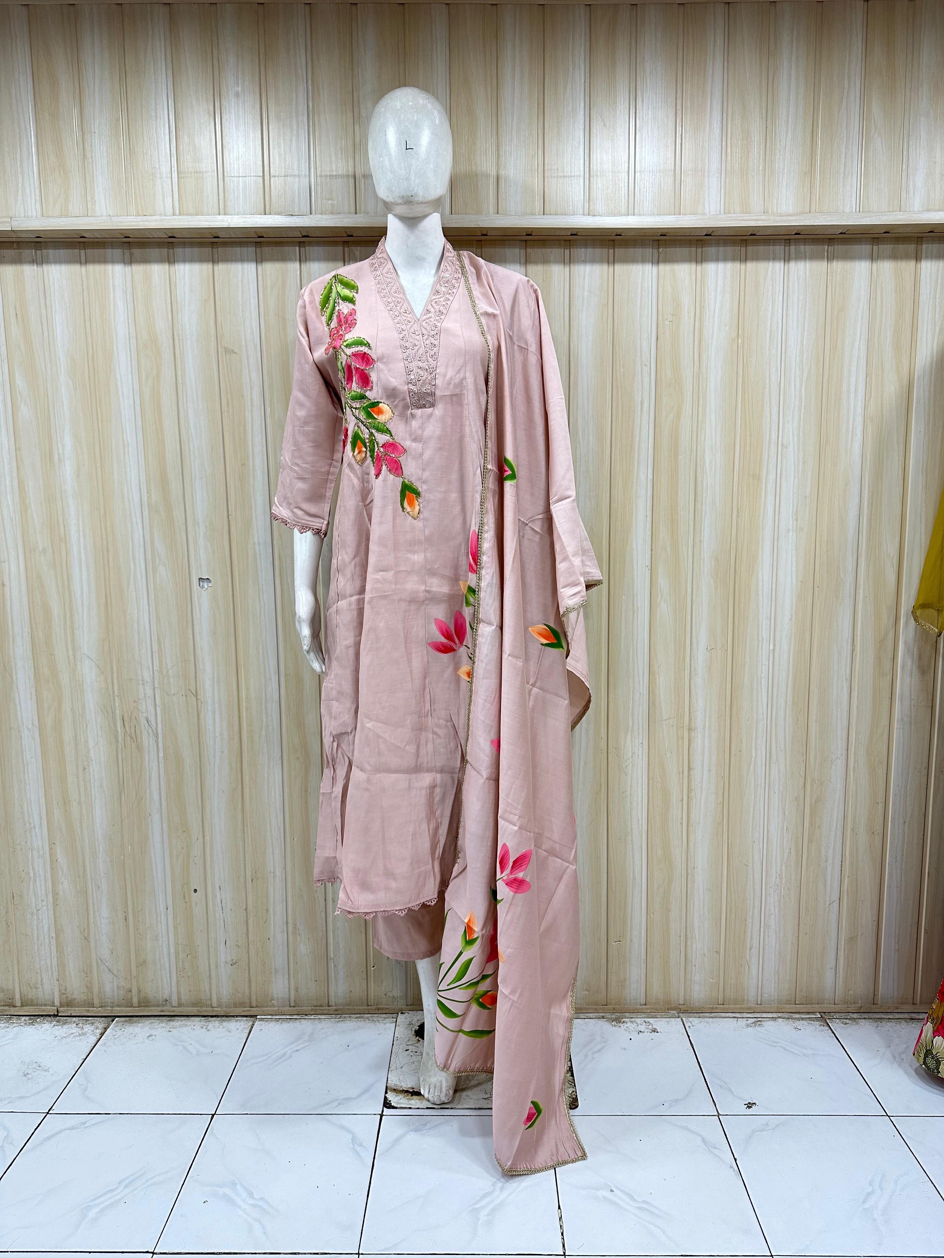 Mannequin wearing a pink outfit with floral embroidery against a striped