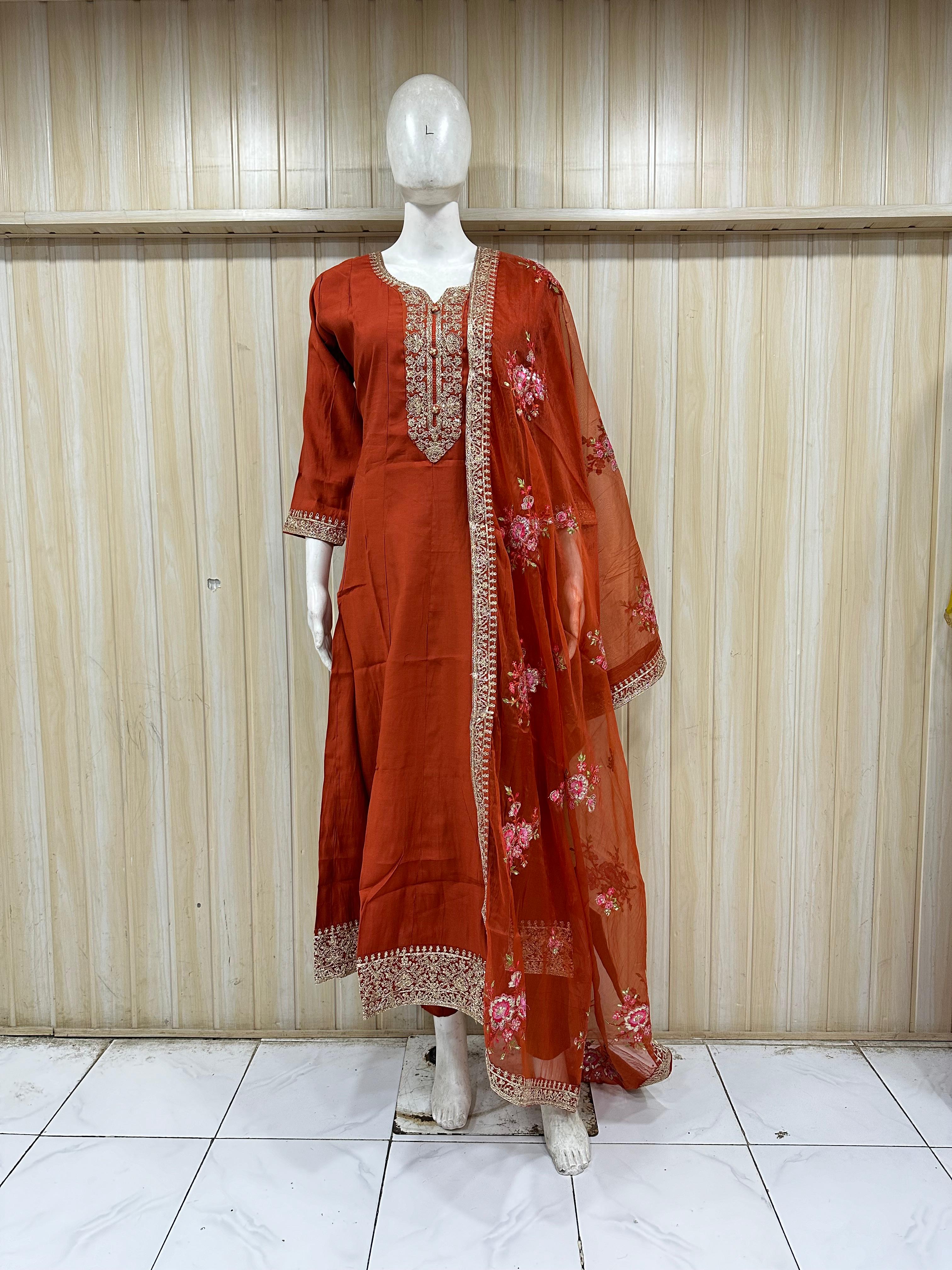Red traditional outfit with floral patterns on a mannequin against a striped