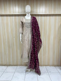 Mannequin wearing a beige traditional outfit with a maroon dupatta against a striped