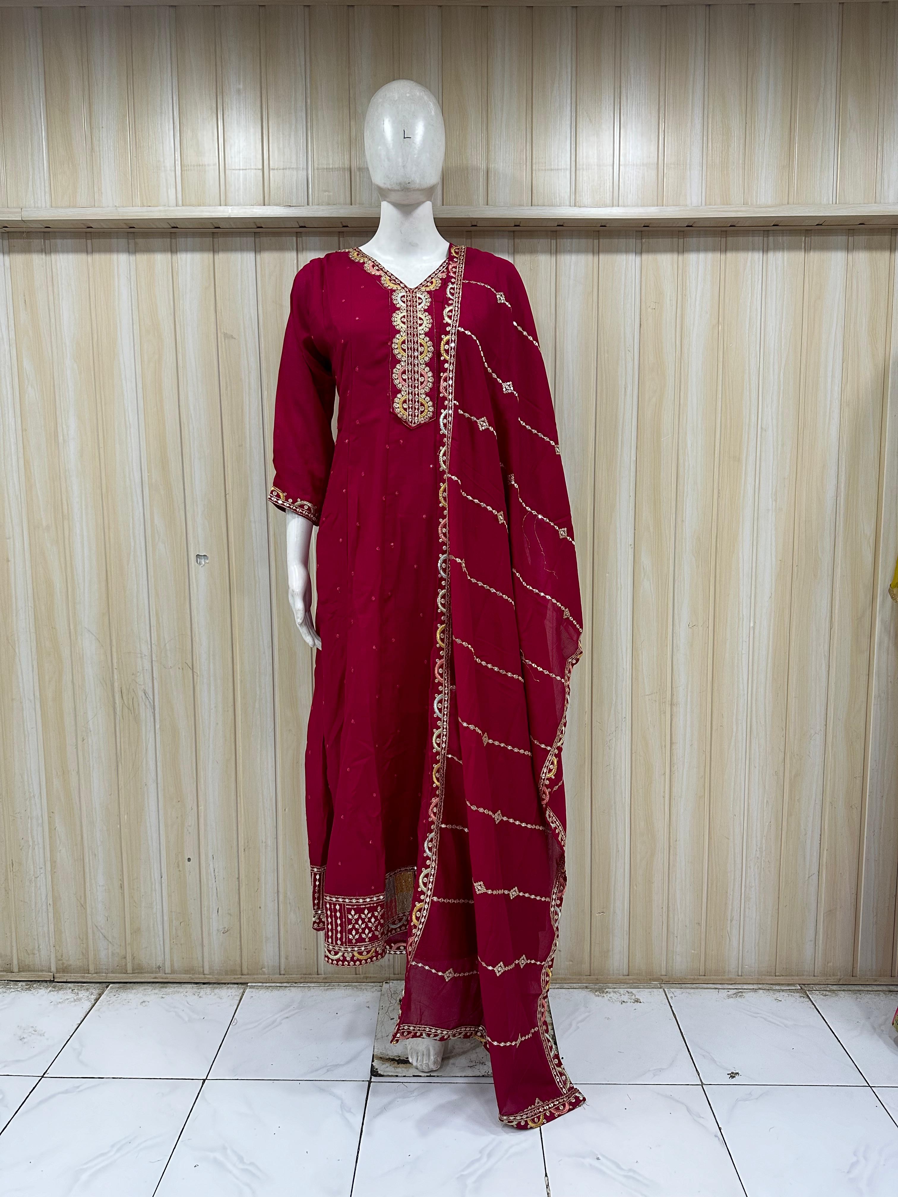 traditional outfit with dark pink embroidery on a mannequin against a striped