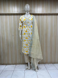 Mannequin wearing a yellow floral dress with a green dupatta against a wooden panel background.