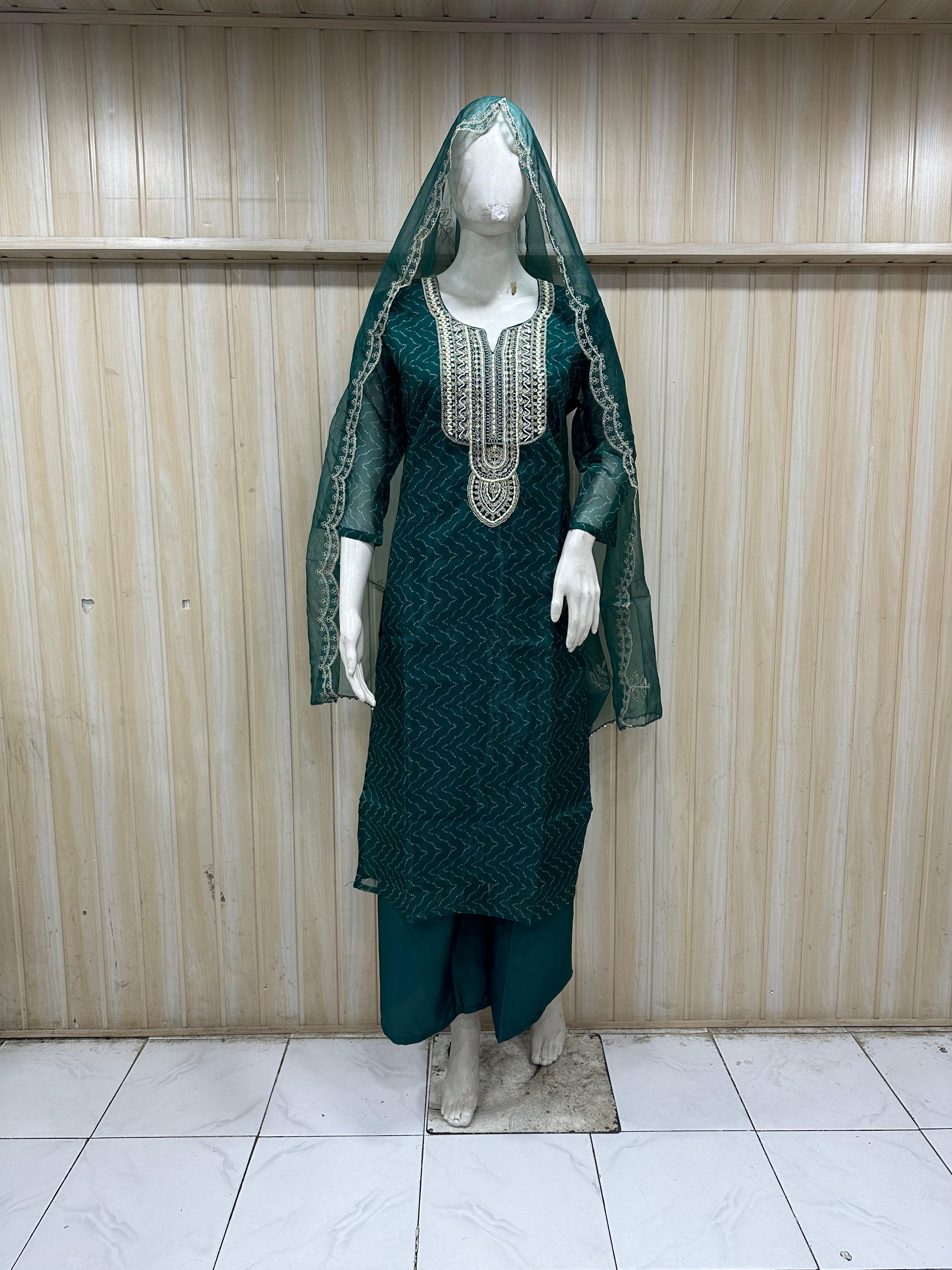 Green embroidered outfit on a mannequin against a striped