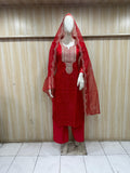 Red embroidered outfit on a mannequin against a striped