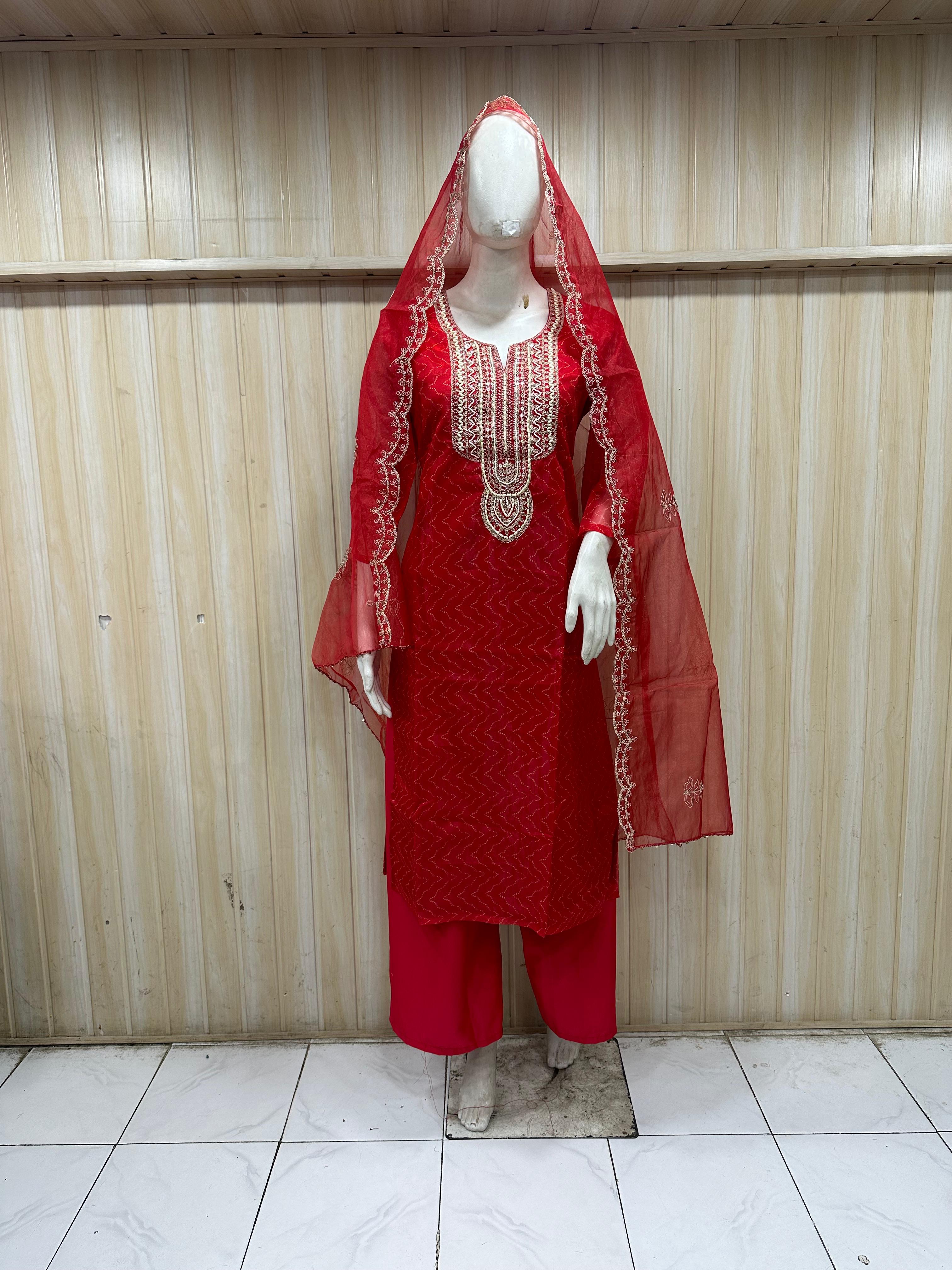 Red embroidered outfit on a mannequin against a striped