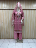 Mannequin wearing a pink traditional outfit with embroidery against a striped
