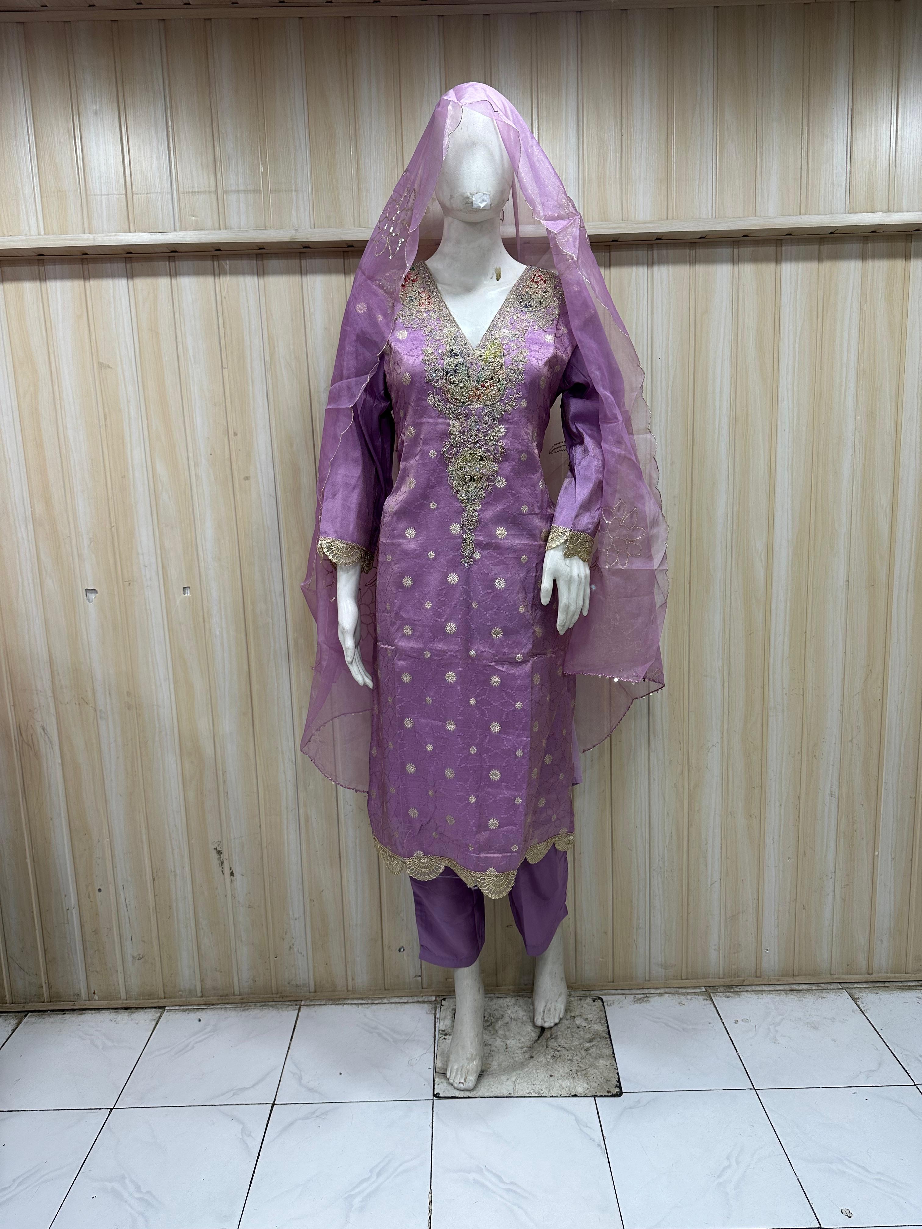Purple traditional outfit with a veil on a mannequin against a striped