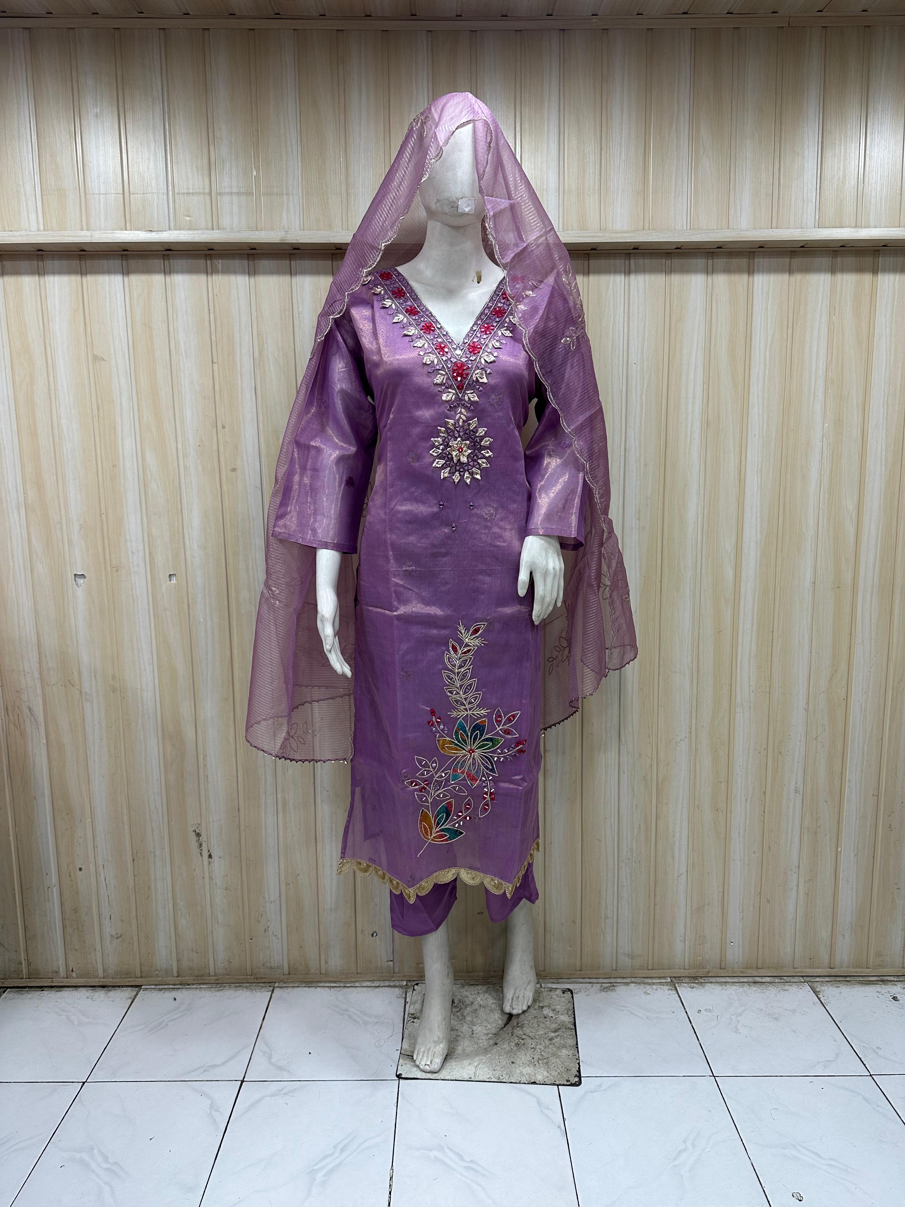Purple embroidered dress on a mannequin against a striped
