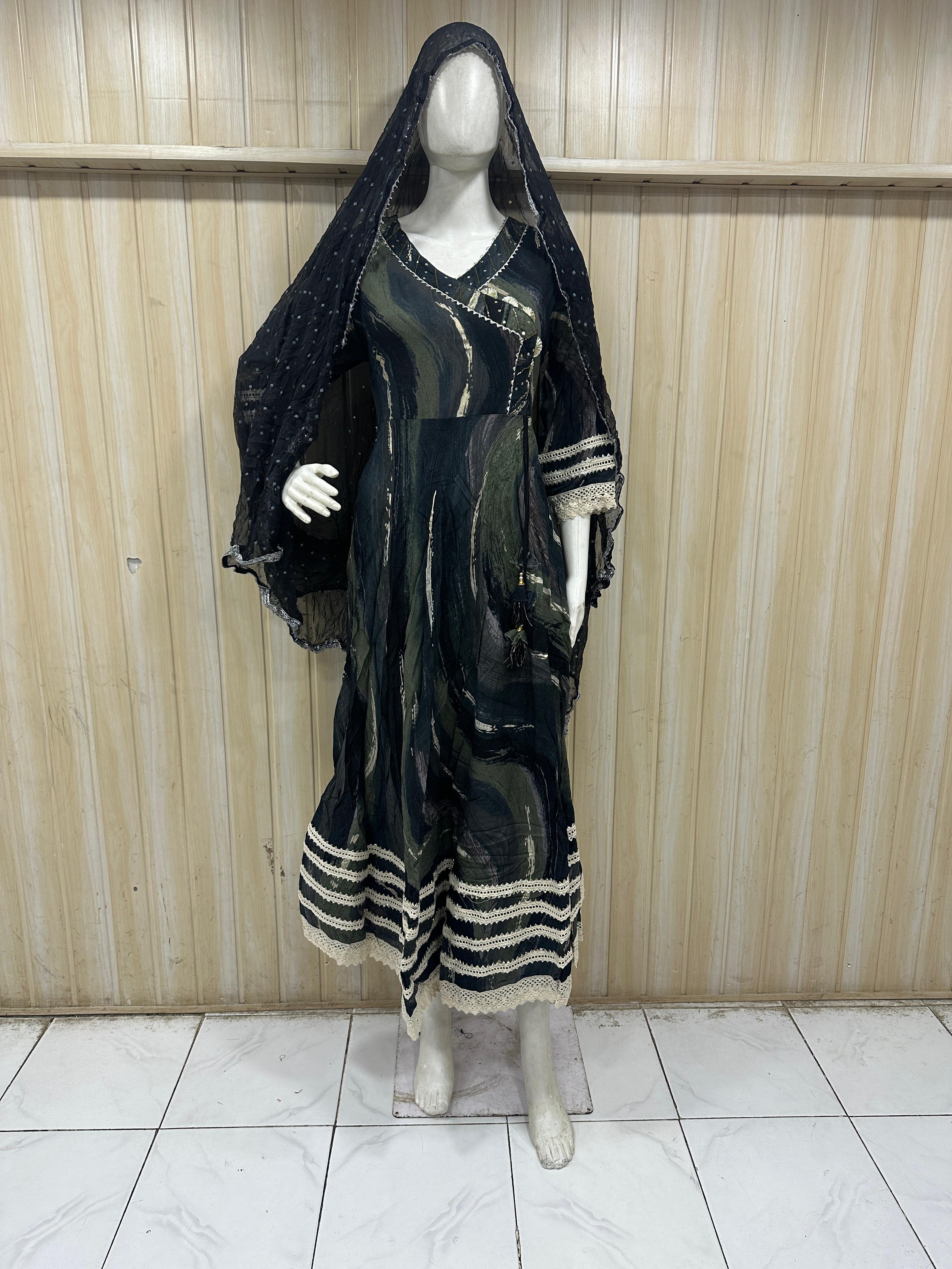 dark green and black traditional outfit with a veil on a mannequin against a striped