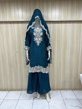 dark green and black traditional outfit with a veil on a mannequin against a striped