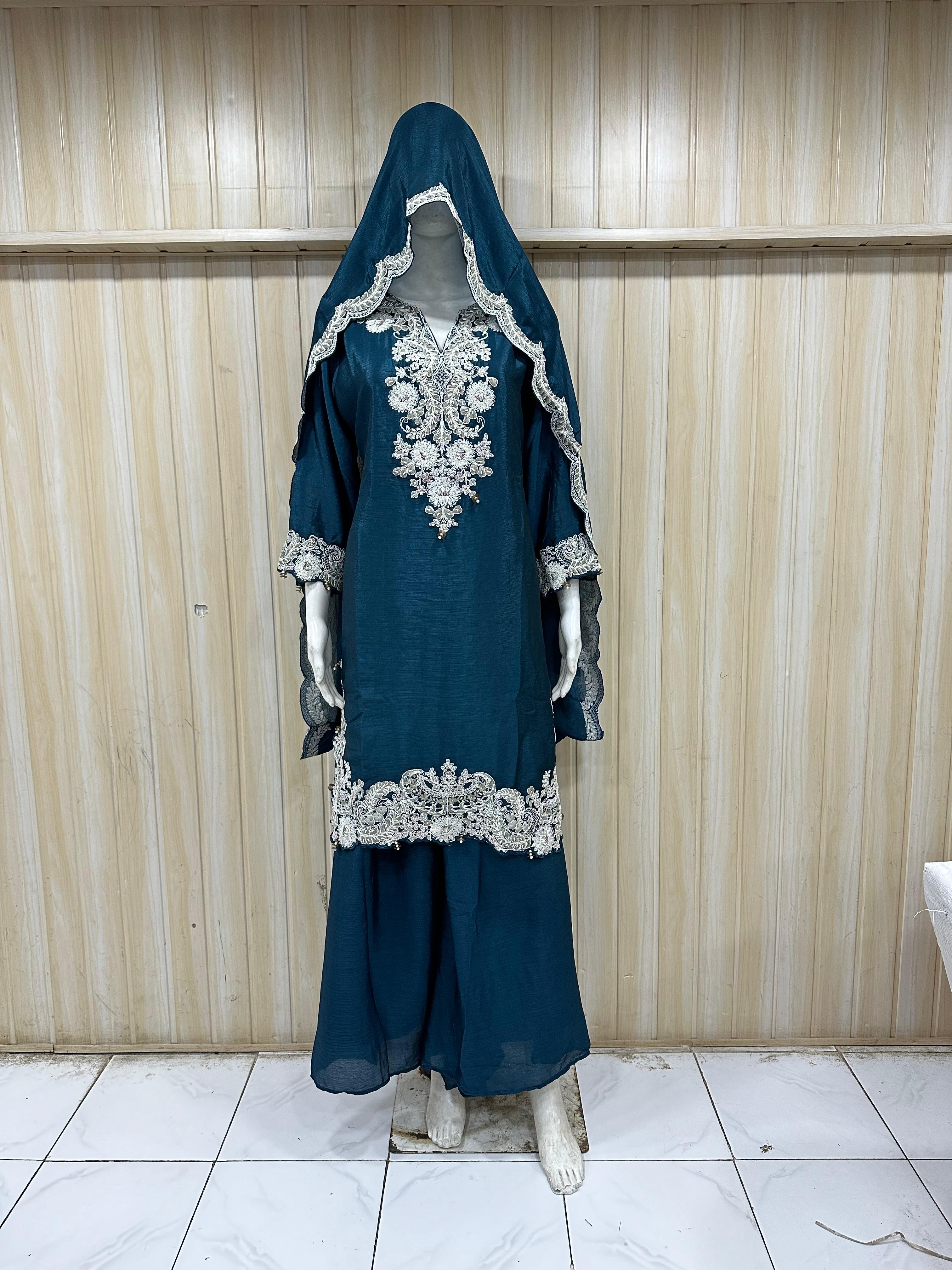 dark green and black traditional outfit with a veil on a mannequin against a striped