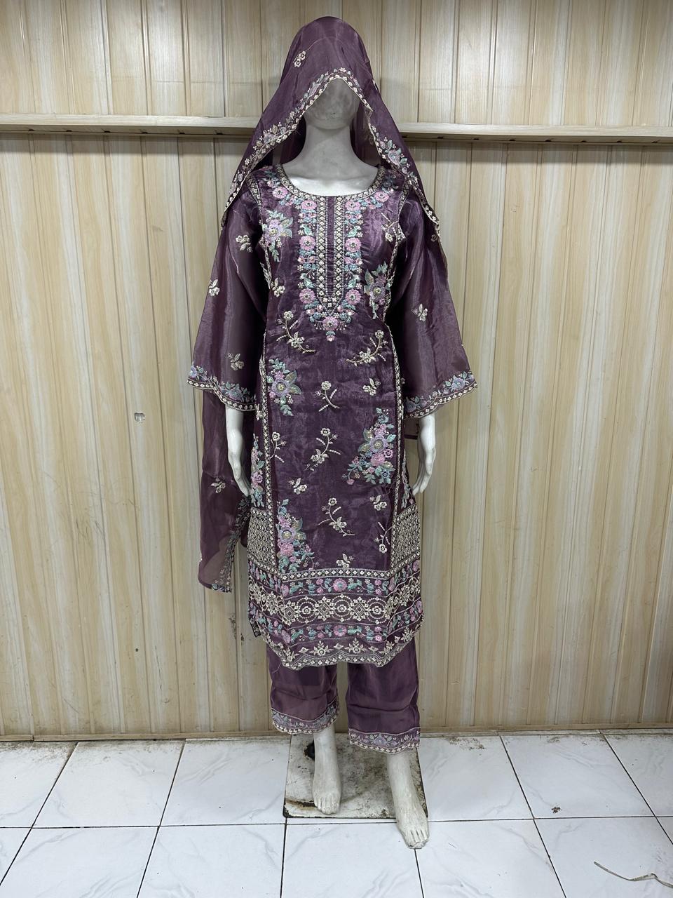Purple embroidered traditional outfit on a mannequin against a striped