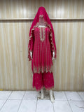pink traditional outfit with embroidered details on a mannequin against a striped