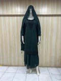 Mannequin wearing a black dress with floral embroidery against a striped