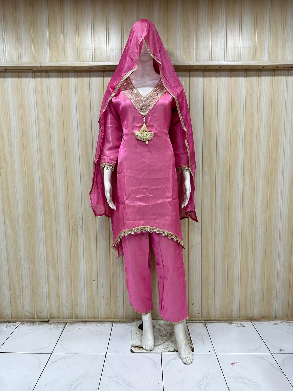 Mannequin wearing a pink traditional outfit with a dupatta against a striped