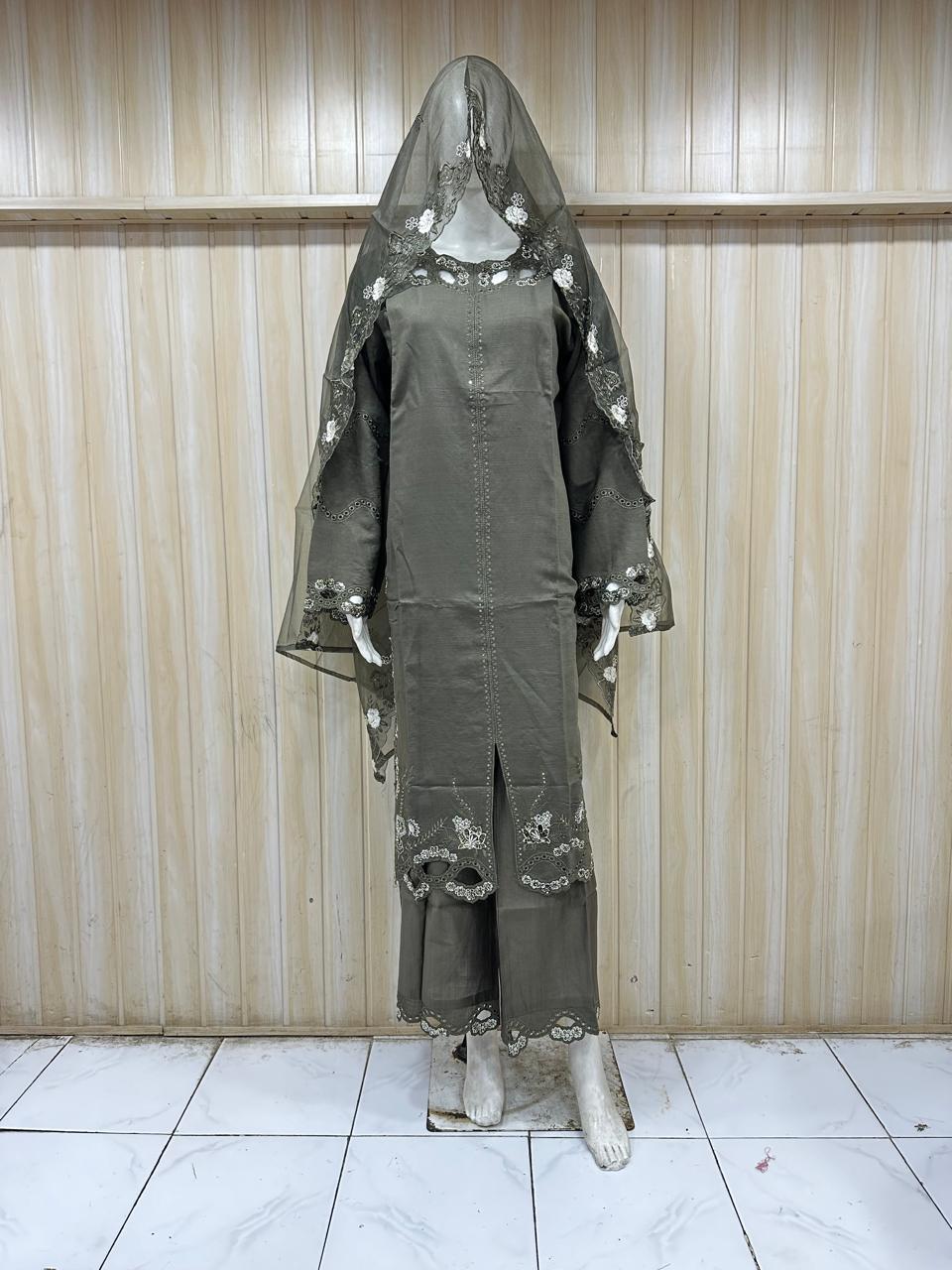 brown embroidered outfit with maroon details on a mannequin against a striped