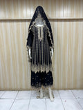 Black embroidered dress with a matching veil on a mannequin against a striped