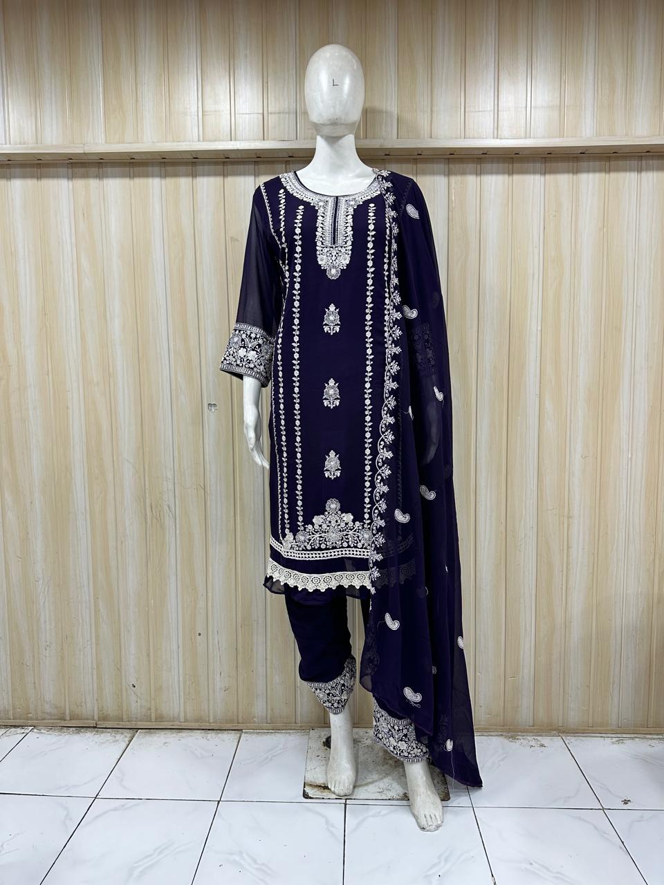 Navy blue embroidered outfit with white patterns on a mannequin against a striped