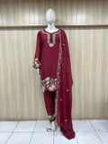 Maroon traditional outfit with floral patterns on a mannequin against a striped