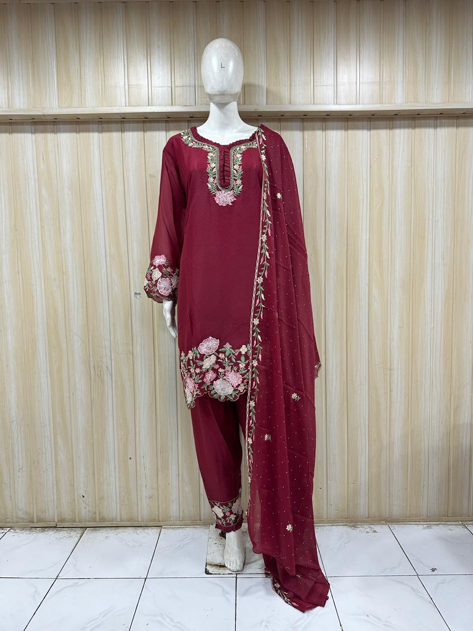 Maroon traditional outfit with floral patterns on a mannequin against a striped