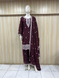 Maroon traditional outfit with white embroidery on a mannequin against a striped