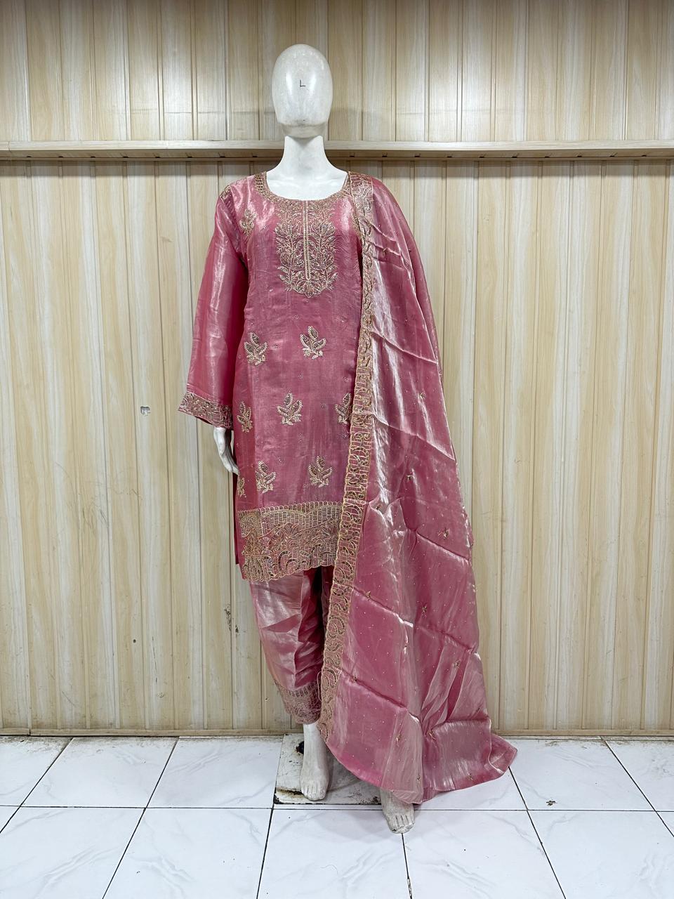 Pink traditional outfit with embroidery on a mannequin against a striped