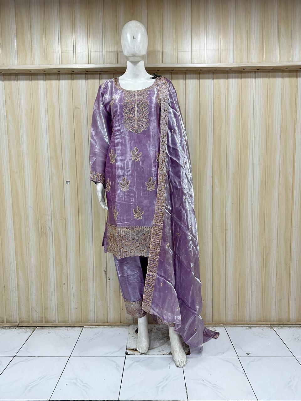 Purple embroidered dress on a mannequin against a wooden panel background