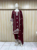 Maroon embroidered outfit with white patterns on a mannequin against a striped