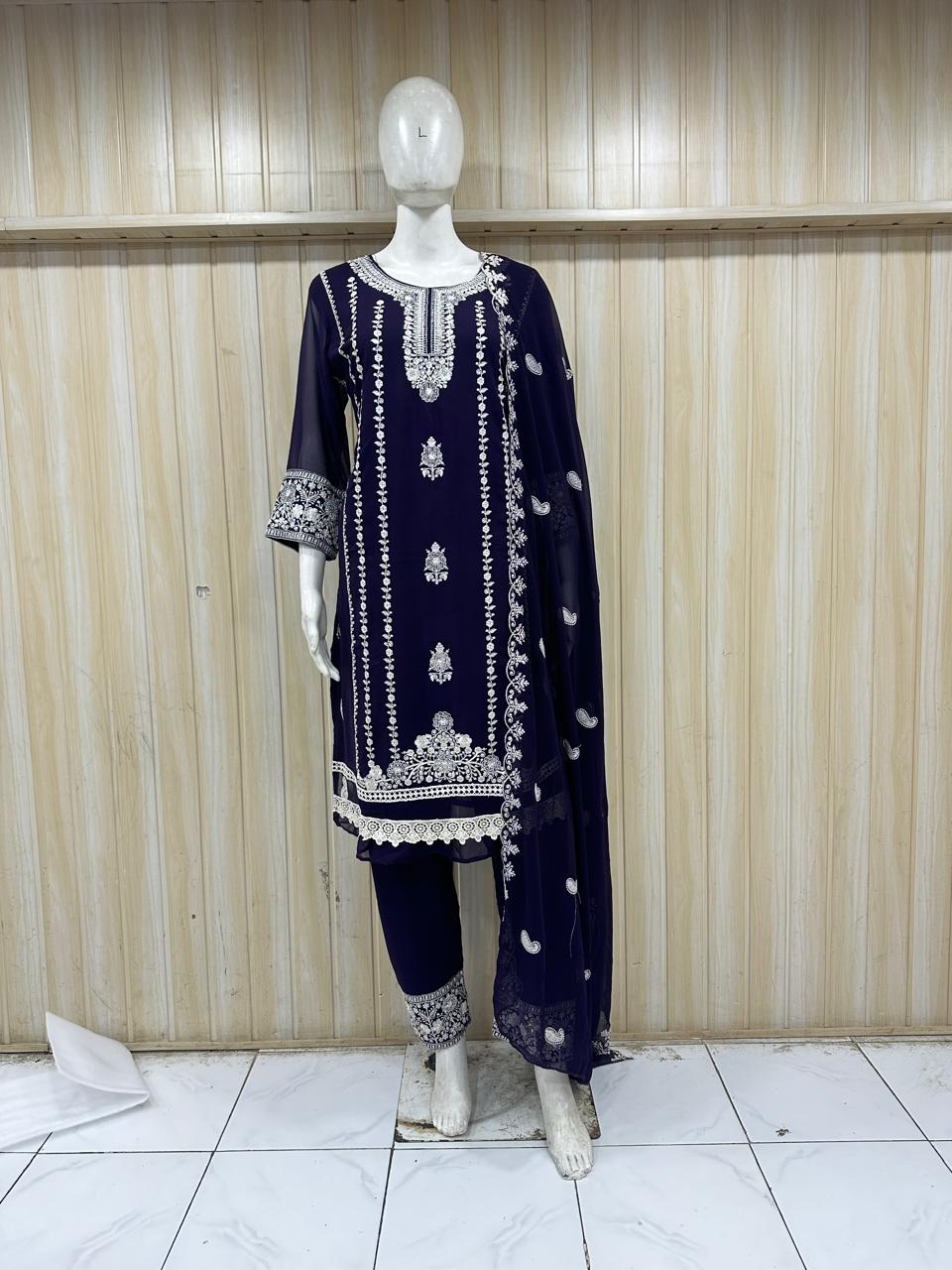 Navy blue embroidered outfit on a mannequin against a striped