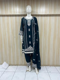 Navy blue embroidered outfit on a mannequin against a wooden panel background