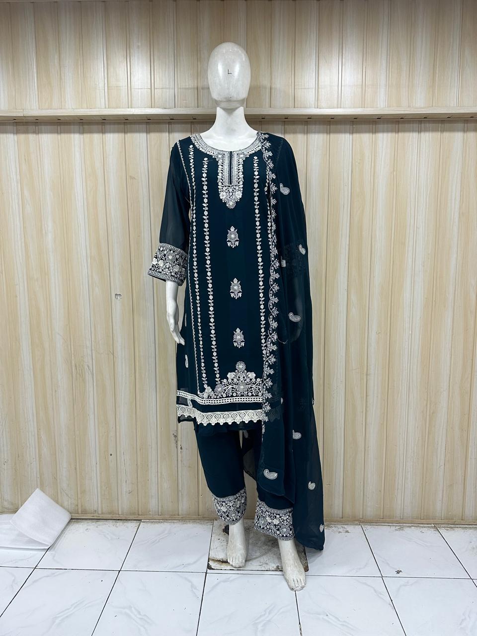 Navy blue embroidered outfit on a mannequin against a wooden panel background