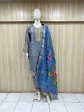 Mannequin wearing a blue embroidered outfit with a floral dupatta against a wooden panel background