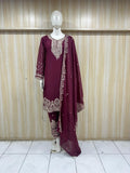 Maroon embroidered traditional outfit on a mannequin against a striped