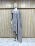 Mannequin wearing a gray embroidered outfit with a long dupatta against a wooden panel background.
