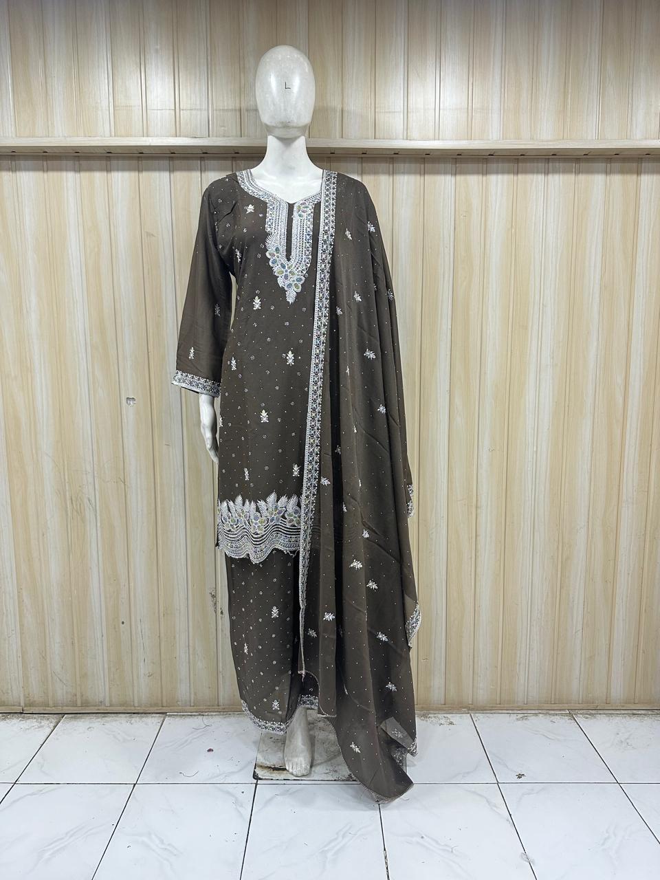 Mannequin wearing a dark gray traditional outfit with white embroidery against a wooden panel background.