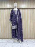 Purple embroidered outfit on a mannequin against a wooden panel background