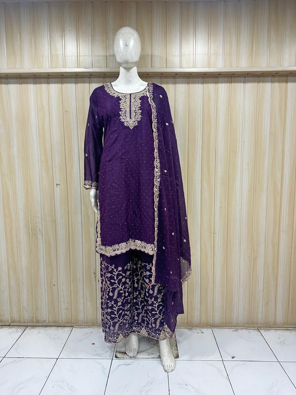 Purple embroidered outfit on a mannequin against a wooden panel background