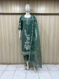Green embroidered outfit on a mannequin against a striped