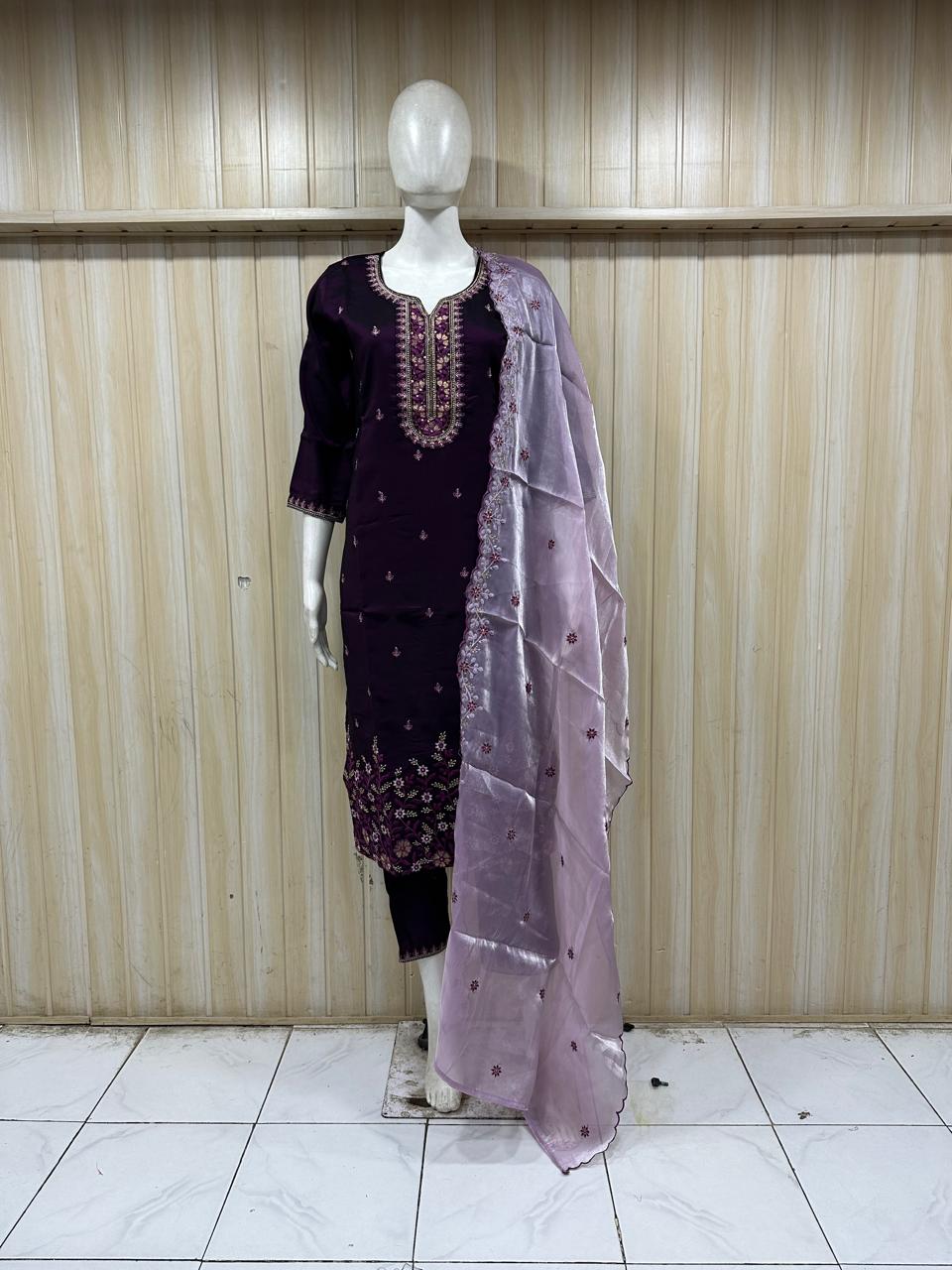Mannequin wearing a dark purple embroidered dress with a matching dupatta against a striped