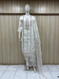 White embroidered outfit on a mannequin against a striped