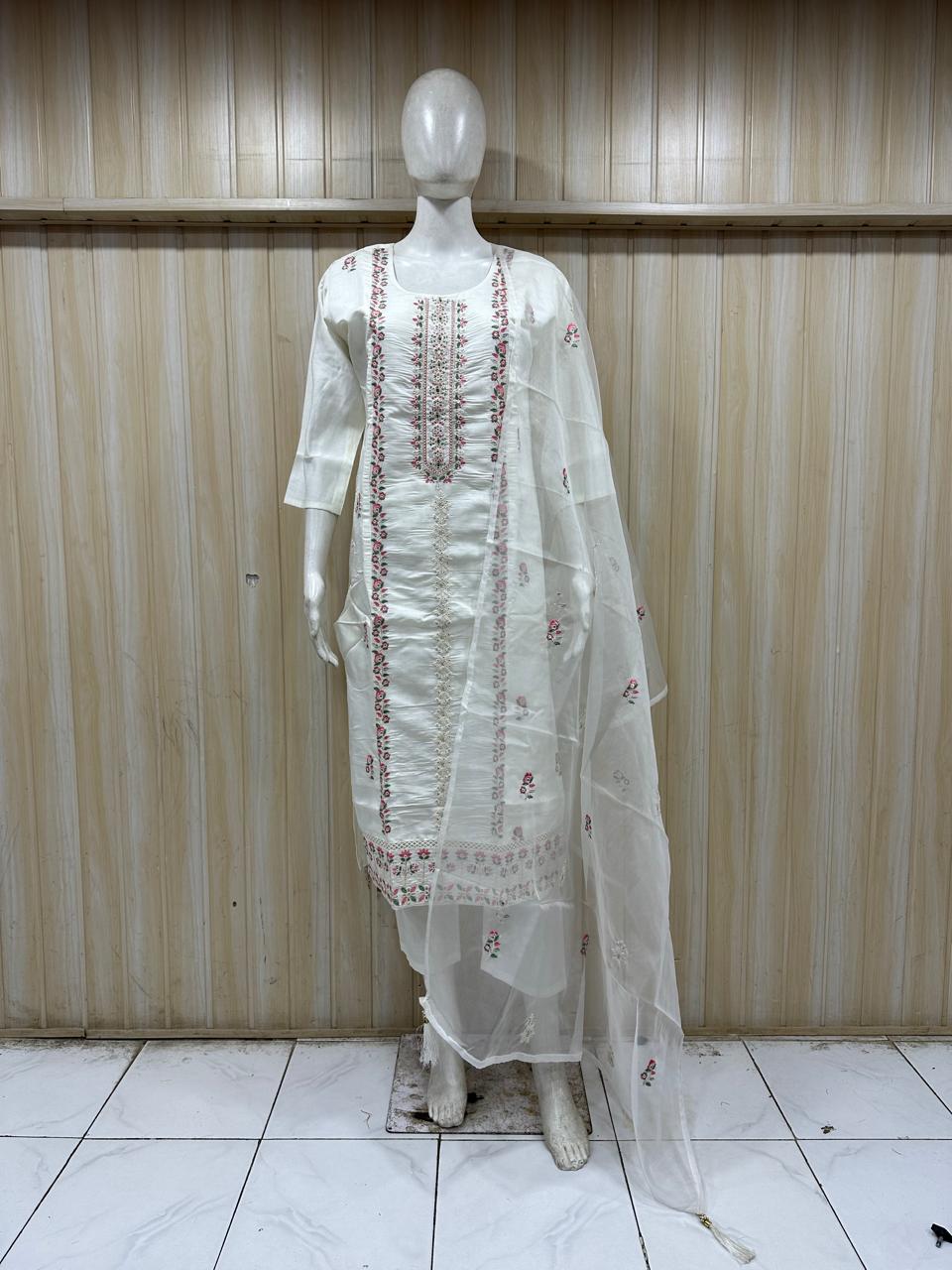 White embroidered outfit on a mannequin against a striped