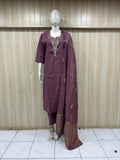 Mannequin wearing a maroon traditional outfit with embroidery against a striped