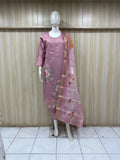 Mannequin wearing a pink colored embroidered outfit against a striped