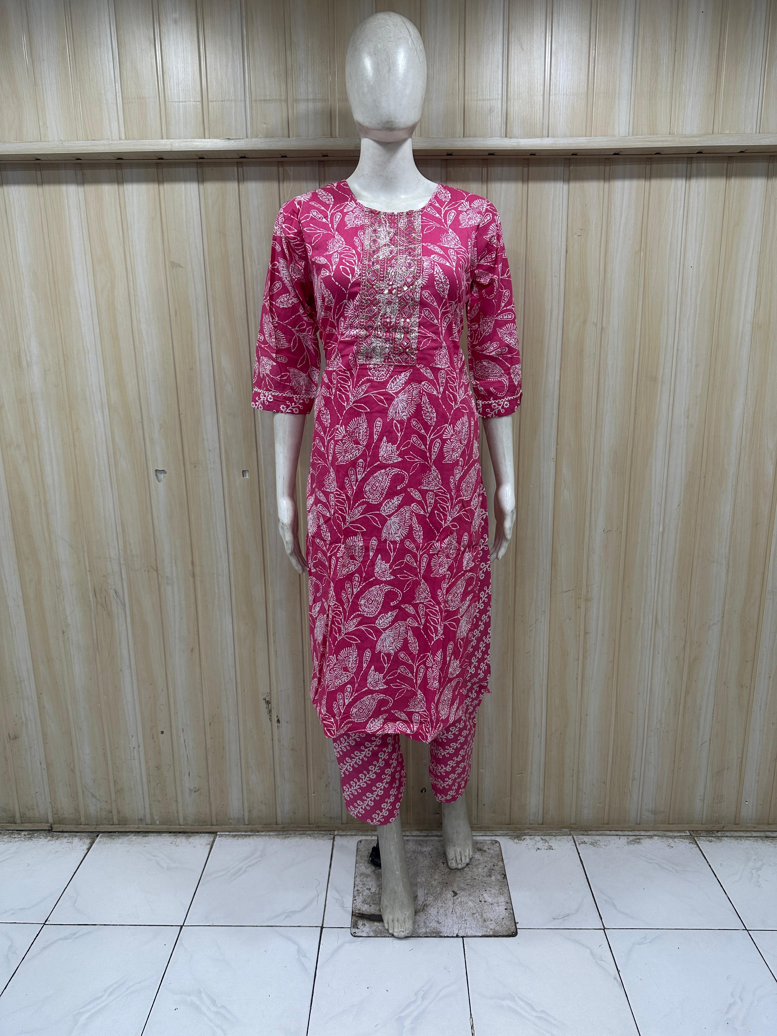 Mannequin wearing a dark pink colored outfit against a striped
