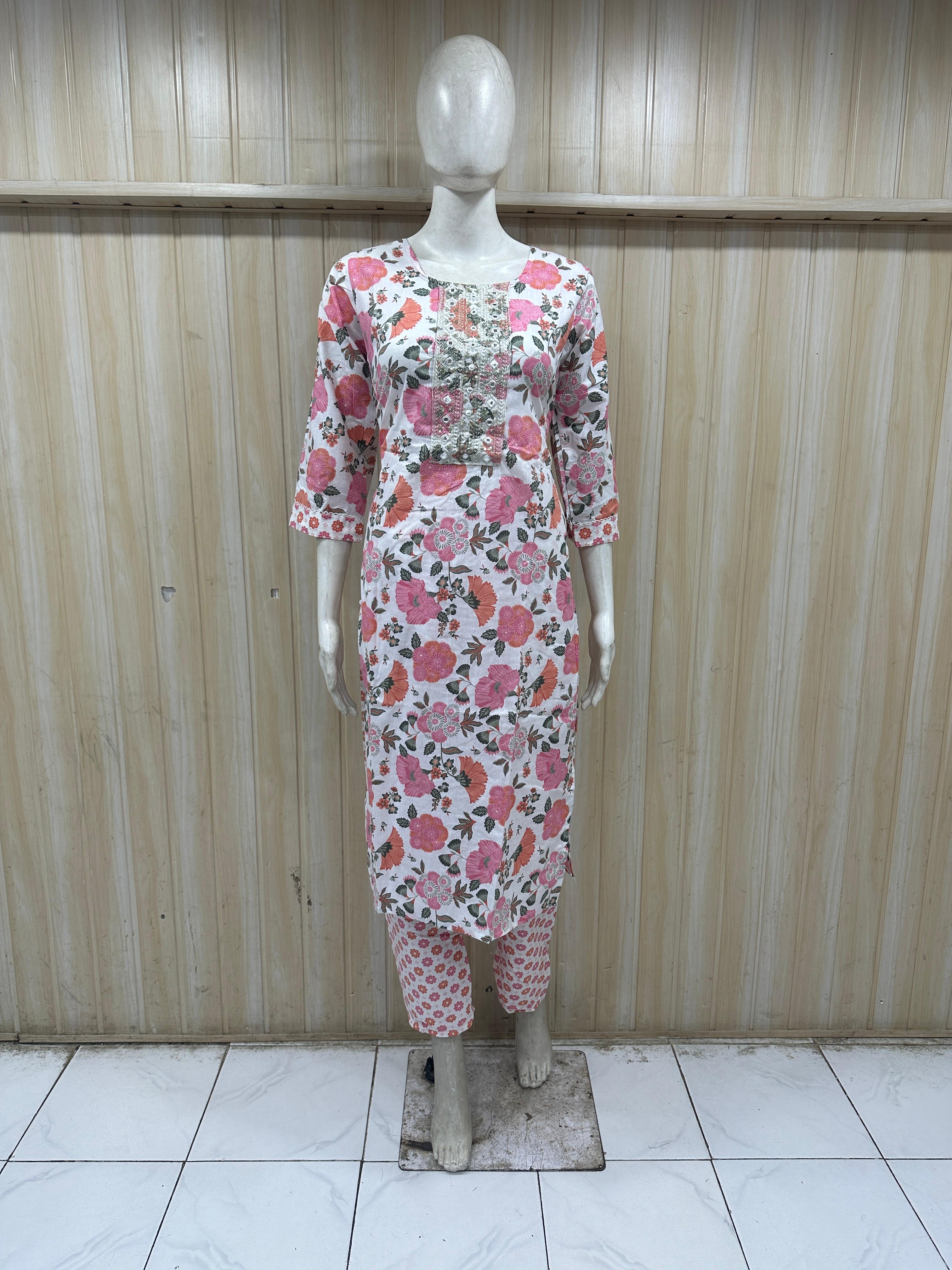 Mannequin wearing a white and pink colored outfit against a striped