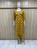 Mannequin wearing a yellow floral dress against a wooden panel background
