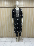 Black outfit with white patterns on a mannequin against a striped