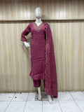 Maroon traditional outfit with dupatta on a mannequin against a striped