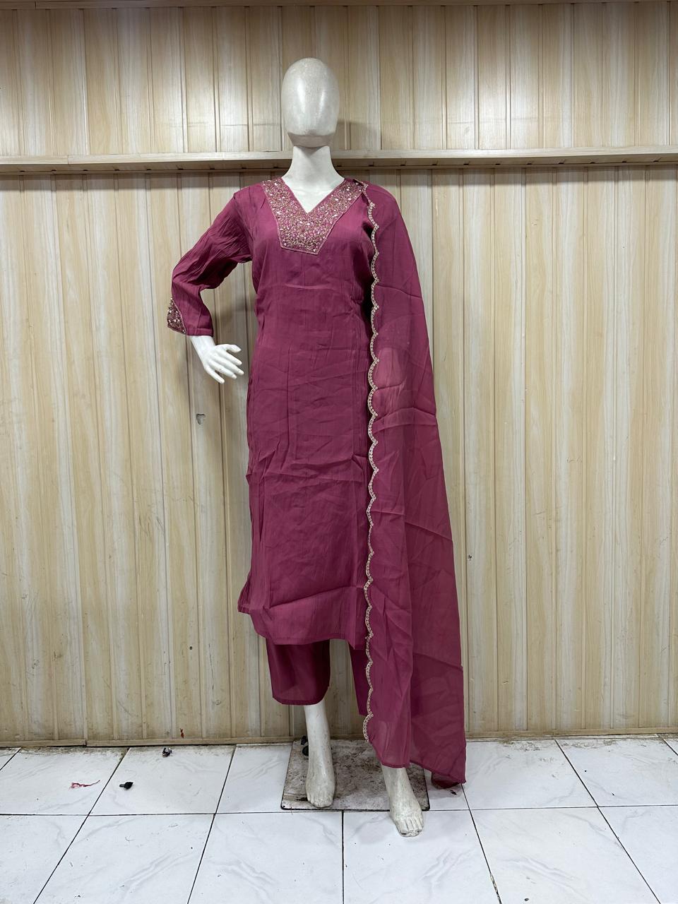 Maroon traditional outfit with dupatta on a mannequin against a striped