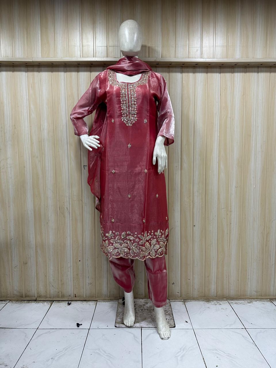 Red traditional outfit with embroidery on a mannequin against a striped